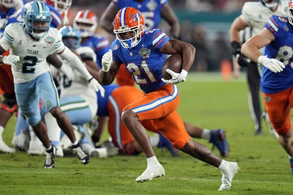 Florida running back KD Daniels (21) runs past Tulane safety Jalen Geiger (2) on a touchdown run during the second half of the Gasparilla Bowl NCAA college football game Friday, Dec. 20, 2024, in Tampa, Fla. (AP Photo/Chris O'Meara)