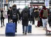 Travellers hold hands as they pass others lining up at the Ottawa International Airport, as airlines cancel or delay flights during a major storm in Ottawa, Friday, Dec. 23, 2022. THE CANADIAN PRESS/Justin Tang