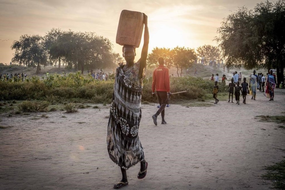 South Sudanese woman carries a jerrican of water in Jonglei state, South Sudan Thursday, Nov. 14, 2024. (AP Photo/Florence Miettaux)