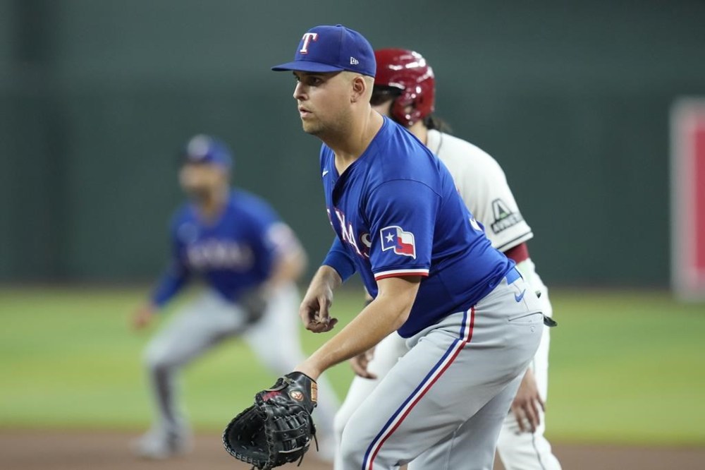 FILE - Texas Rangers first baseman Nathaniel Lowe watches a pitch during the fourth inning of a baseball game against the Arizona Diamondbacks, Sept. 11, 2024, in Phoenix. (AP Photo/Ross D. Franklin, File)