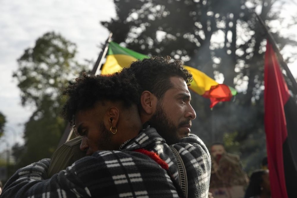 People embrace during a protest in front of the prosecutor's office following the disappearance in Guayaquil of four children who were last seen running away from a military convoy, in Quito, Ecuador, Monday, Dec. 23, 2024. (AP Photo/Carlos Noriega)