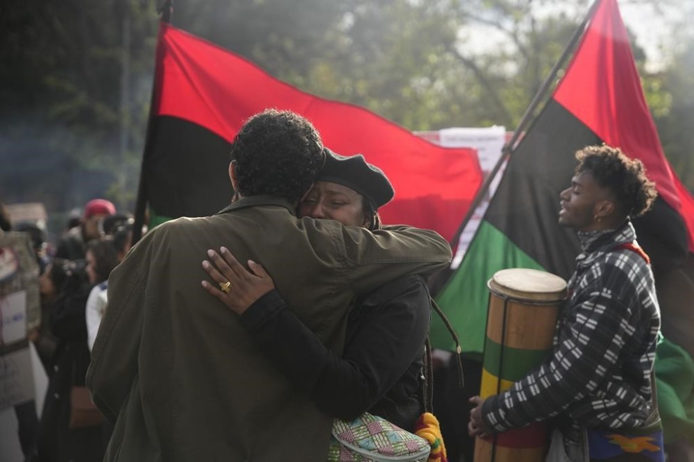 People embrace during a protest in front of the prosecutor's office following the disappearance in Guayaquil of four children who were last seen running away from a military convoy, in Quito, Ecuador, Monday, Dec. 23, 2024. (AP Photo/Carlos Noriega)