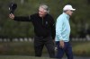 Gary Player, left, acknowledges the crowd as he and Nick Price, right, walk to the 18th green during the final round of the PNC Championship golf tournament, Sunday, Dec. 22, 2024, in Orlando, Fla. (AP Photo/Phelan M. Ebenhack)