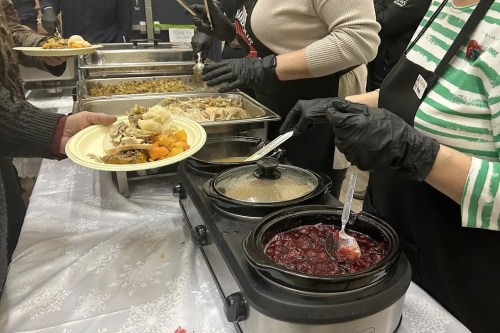 A volunteer serves gravy and cranberry sauce at the Souls Harbour Rescue Mission in Lower Sackville, N.S., Tuesday, Dec. 24, 2024. The charity expects to feed about 600 people over Christmas Eve and Christmas Day. THE CANADIAN PRESS/Cassidy McMackon