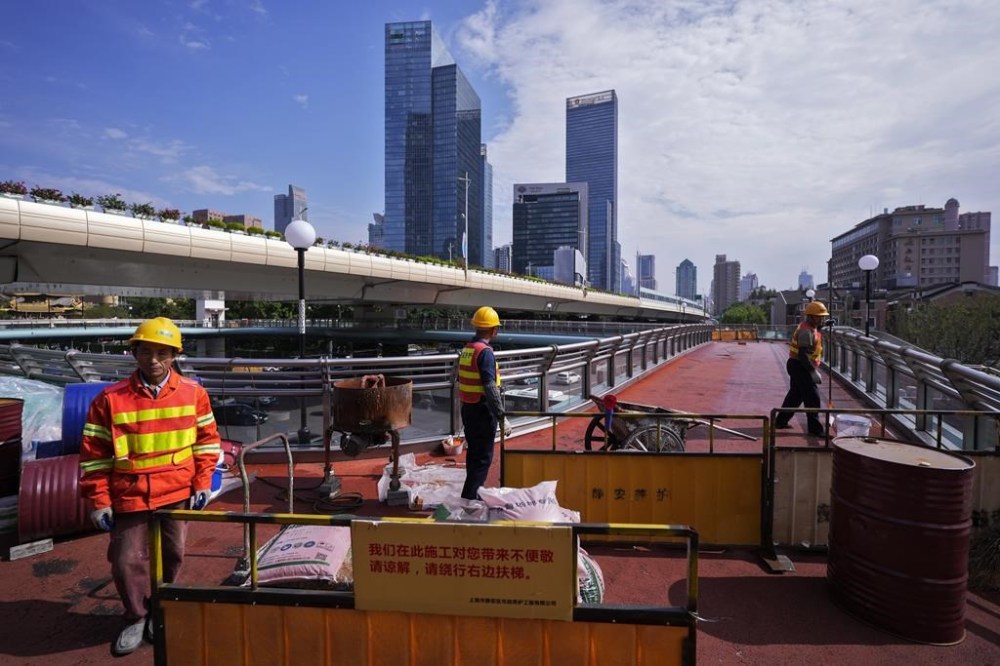 FILE - Workers refurbish an overhead pedestrian bridge in Shanghai, Wednesday, Oct. 9, 2024. (AP Photo/Andy Wong, File)