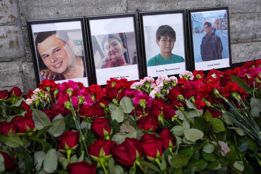 Flowers and portraits are placed at the Consulate of Azerbaijan in the memory of victims of the Azerbaijan Airlines' Embraer 190 that crashed near the Kazakhstan's airport of Aktau, in St. Petersburg, Russia, Thursday, Dec. 26, 2024. (AP Photo/Dmitri Lovetsky)