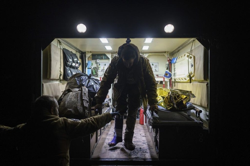 An injured Ukrainian serviceman walks out of an ambulance at Medical Service