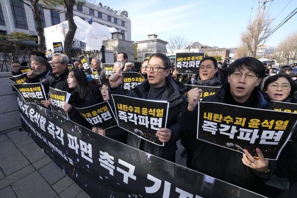 Protesters stage a rally demanding the arrest of impeached South Korean President Yoon Suk Yeol outside of the Constitutional Court in Seoul, South Korea, Friday, Dec. 27, 2024. The signs read,