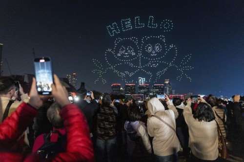People watch the panda-themed drone show at the waterfront of the Victoria Harbour in Hong Kong, Saturday, Dec. 28, 2024. (AP Photo/Chan Long Hei)
