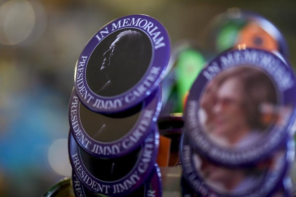 An In Memorium button for former President Jimmy Carter is seen inside the Plains Trading Post, Monday, Dec. 30, 2024, in Plains, Ga. Former President Jimmy Carter died Sunday at the age of 100. (AP Photo/Mike Stewart)