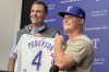Texas Rangers president of baseball operations Chris Young, left, poses for photos with Joc Pederson during a news conference announcing Pederson's two-year contract with the team, Monday, Dec. 30, 2024, in Arlington, Texas. (AP Photo/Stephen Hawkins)