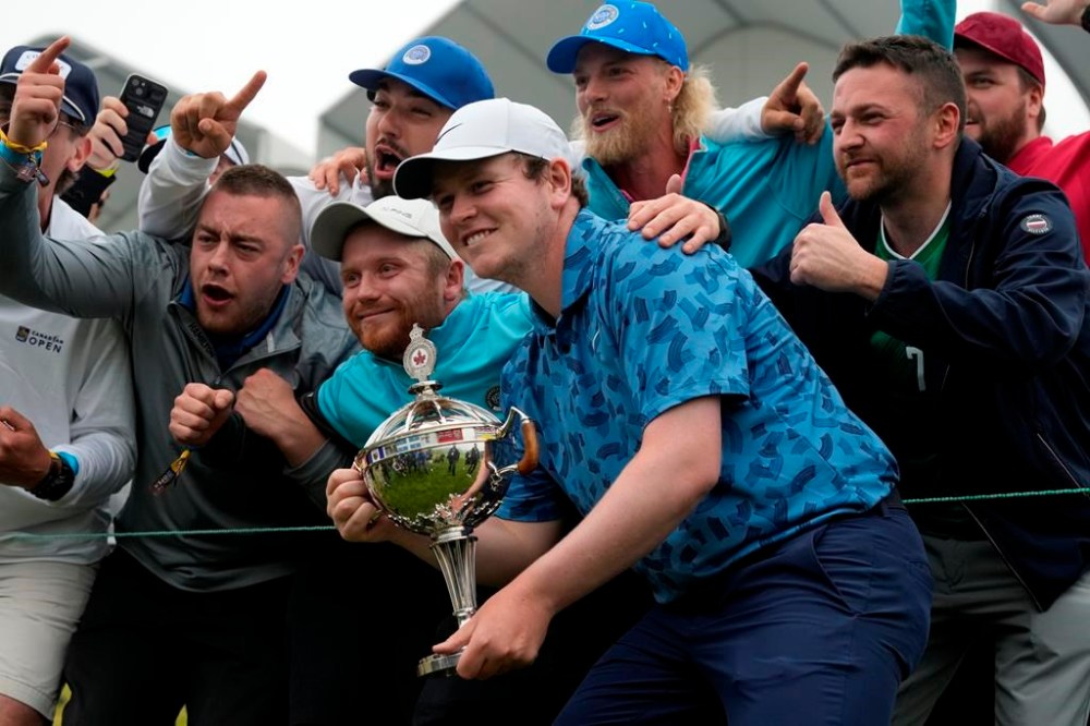 Scotland's Robert MacIntyre poses with fans while holding the championship trophy after winning the Canadian Open golf tournament in Hamilton, Ontario on Sunday June 2, 2024. Golf continued to be on the upswing in Canada in 2024 and Brooke Henderson expects even more in the new year. THE CANADIAN PRESS/Frank Gunn
