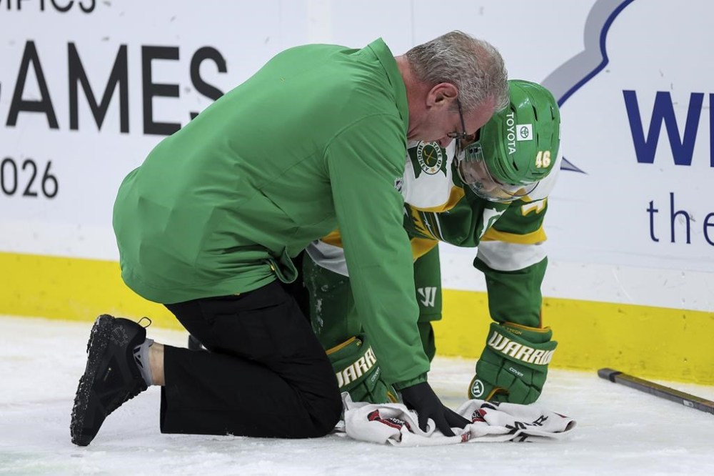Minnesota Wild athletic trainer John Worley talks to defenseman Jared Spurgeon after sustaining an injury during the second period of an NHL hockey game against the Nashville Predators Tuesday, Dec. 31, 2024, in St. Paul, Minn. (AP Photo/Matt Krohn)
