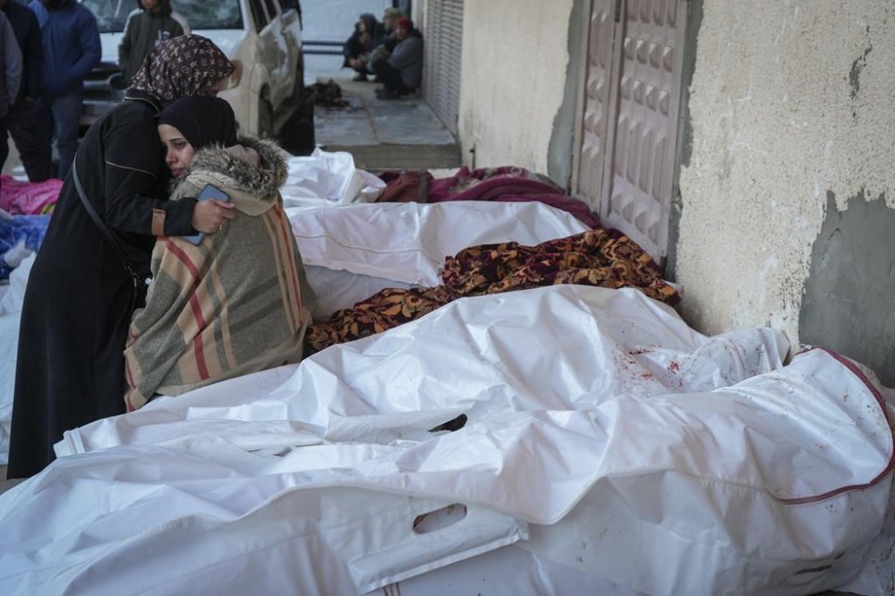 Relatives mourn over the bodies of victims of overnight Israeli army strikes at multiple locations in central Gaza Strip, at Al-Aqsa Martyrs Hospital in Deir al-Balah, Friday, Jan. 3, 2025. According to Al-Aqsa Martyrs Hospital, 30 people, including 10 women and 7 children, were killed in several attacks overnight in central Gaza. (AP Photo/Abdel Kareem Hana)