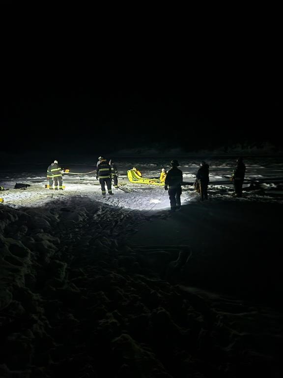 Police and firefighters perform a technical rescue to help two people who were stranded after their snowmobile fell through river ice in very cold weather in Thompson, Man., in a Wednesday, Jan. 1, 2025, handout photo. THE CANADIAN PRESS/HO-Manitoba RCMP, *MANDATORY CREDIT*