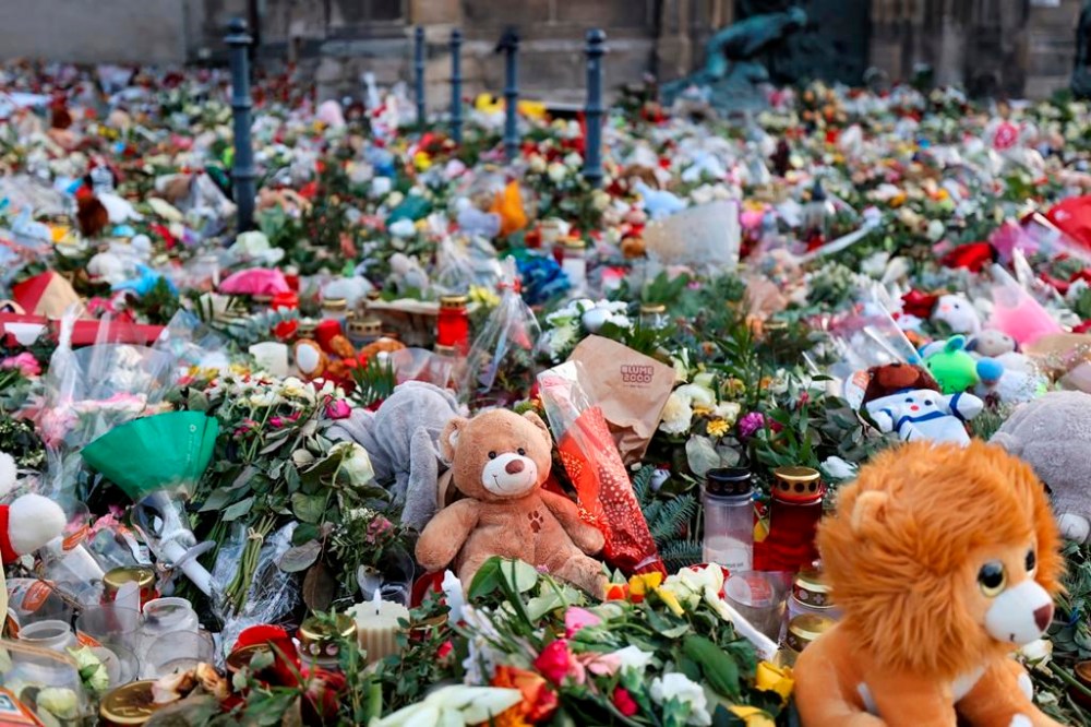 Hundreds of candles, flowers and cuddly toys can be found in front of St. John's Church in Magdeburg, Germany, Friday Jan. 3, 2025, for the victims of the attack at Magdeburg's Christmas market. (Peter Gercke/dpa via AP)
