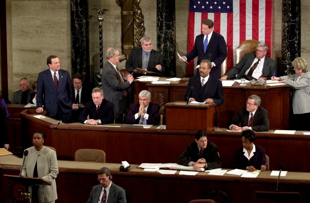 FILE - Rep. Cynthia McKinney, D-Ga., lower left, objects to Florida's electoral vote count results, as Vice President Al Gore, standing, top center, and House Speaker Dennis Hastert, R-Ill., seated, top right, listen on the floor of the U.S. House of Representatives, in Washington, Jan. 6, 2001. Other members present, seated at left in middle row are: Sen. Mitch McConnell, R-Ky., Chris Dodd, D-Ct, hand over mouth., Chaka Fattah, D-Pa., standing at podium and Rep. William Thomas, R-Calif. Others not identified. (AP Photo/Kenneth Lambert, File)