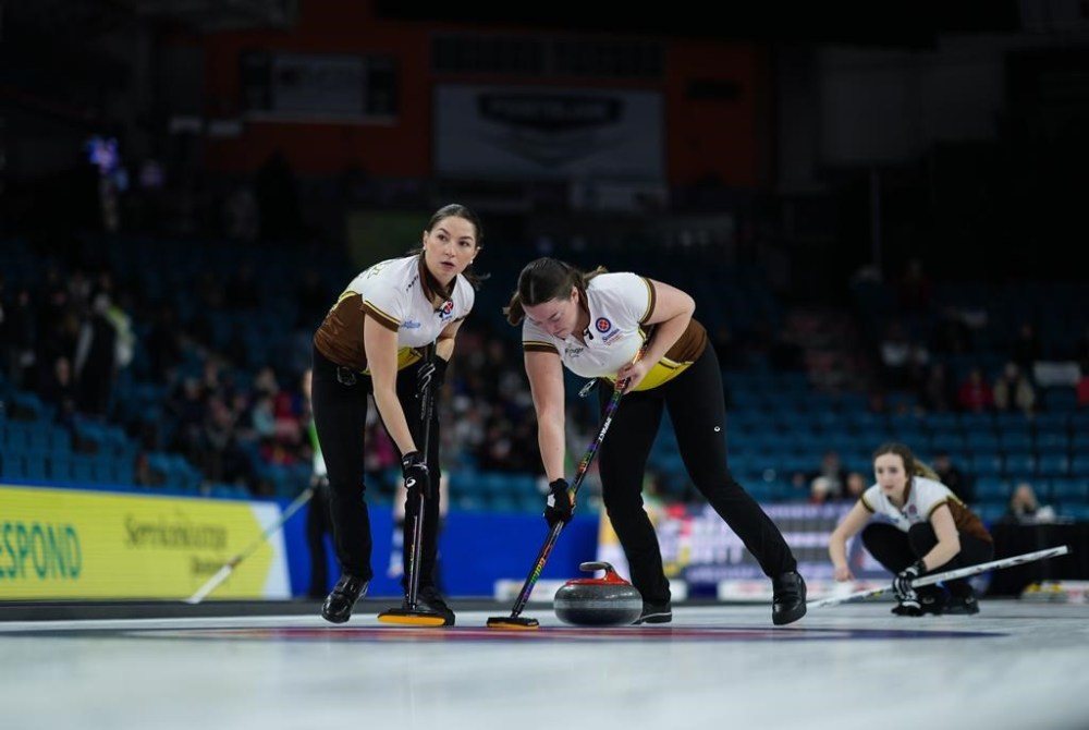 Manitoba third Karlee Burgess, left, and alternate Lauren Lenentine sweep while playing Northwest Territories at the Scotties Tournament of Hearts in Kamloops, B.C., on February 21, 2023. THE CANADIAN PRESS/Darryl Dyck