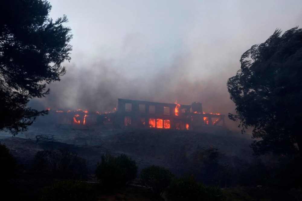 A residence burns as the Palisades Fire advances in the Pacific Palisades neighborhood of Los Angeles, Tuesday, Jan. 7, 2025. (AP Photo/Etienne Laurent)