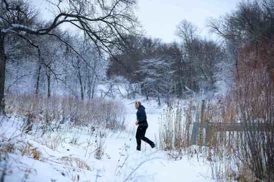 A man jogs through a winter wonderland setting of fresh, heavy snow at Omand's Creek on Monday. Forecasters are calling for a chilly end to the week, but predict another warm spell will blow into Winnipeg next week. (Ruth Bonneville / Free Press)