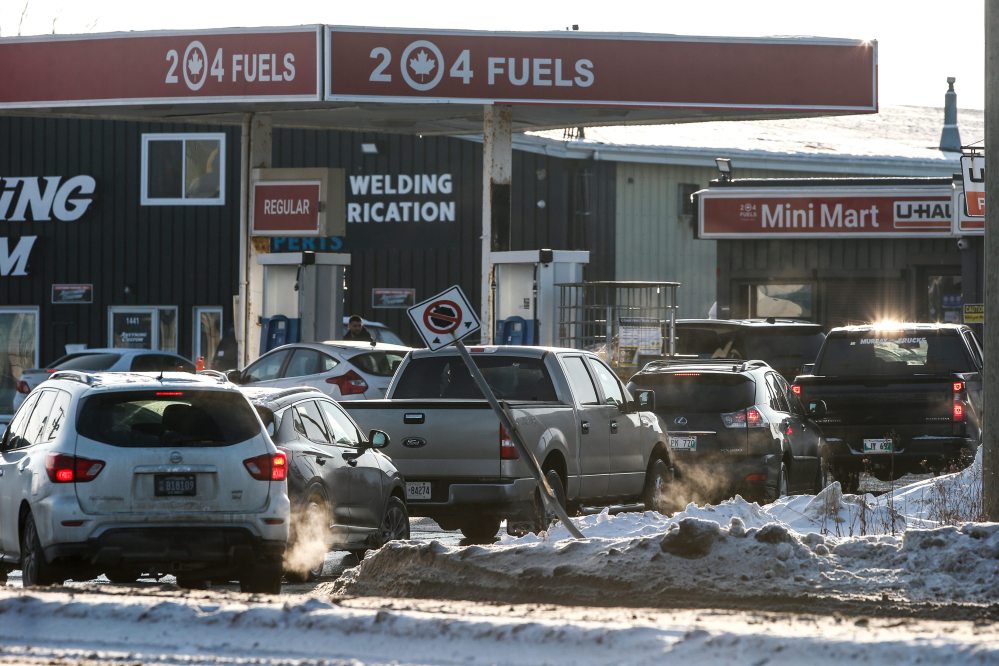 JOHN WOODS / FREE PRESS
Drivers line up for lower priced gas at a station on Waverley Street Tuesday, Dec. 24. Provincial gas taxes will be applied again in the new year.
