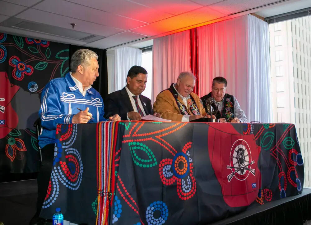 Manitoba Métis Federation President David Chartrand (second from right) signs a copy of the Red River Métis Self Government Treaty at the MMF building in Winnipeg Saturday, along with (from left) Minster of Norther Affairs Dan Vandal, Federal Minister of Crown-Indigenous Relations Gary Anandasangaree and lead negotiator for the Red River Métis, Allan Benoit. (Brook Jones / Free Press)