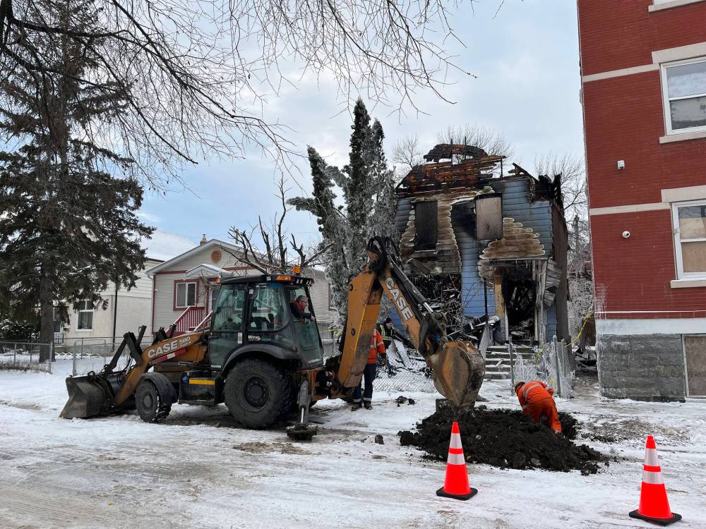 MALAK ABAS / FREE PRESS
A family was allowed back into their Young Street home later Tuesday to find only water damage. The vacant house next door was so damaged an emergency demolition is planned.