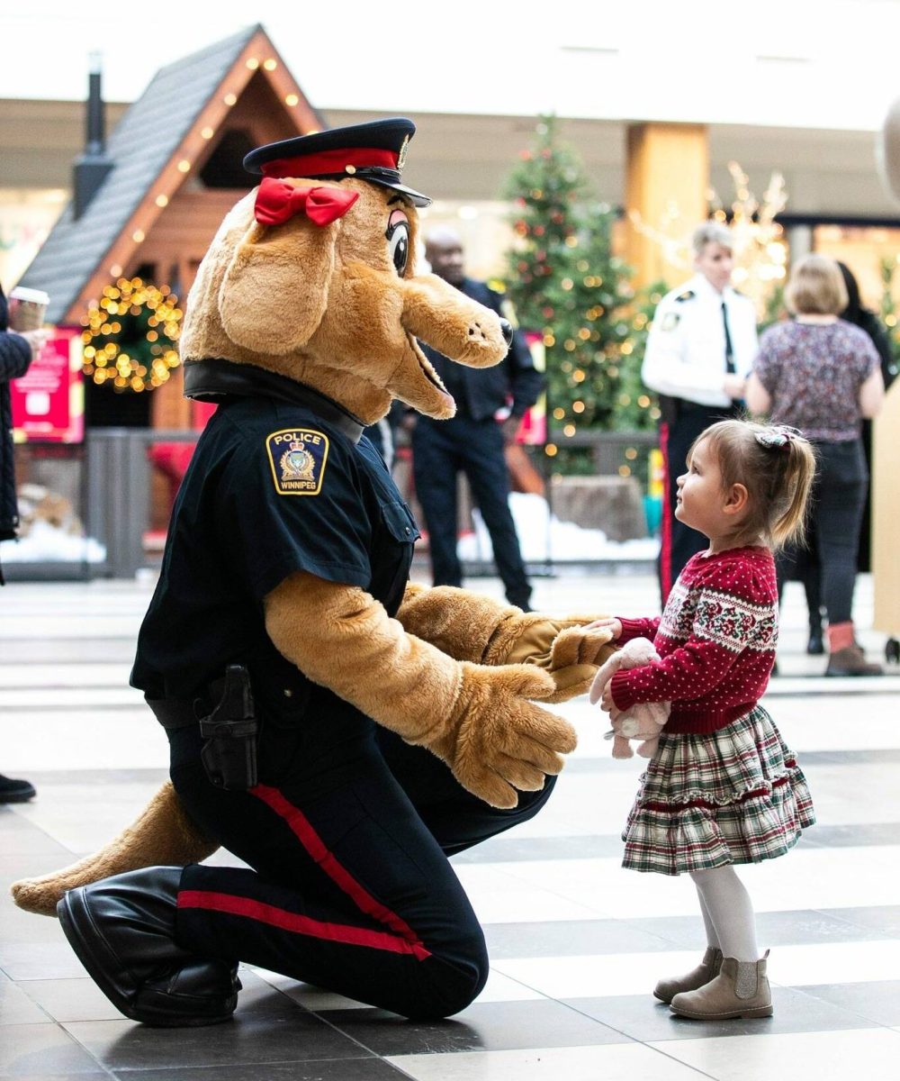 Two-year-old Ivy says hello to Sage, a Winnipeg Police Service mascot, at Polo Park mall on Wednesday. (Mikaela MacKenzie / Free Press)