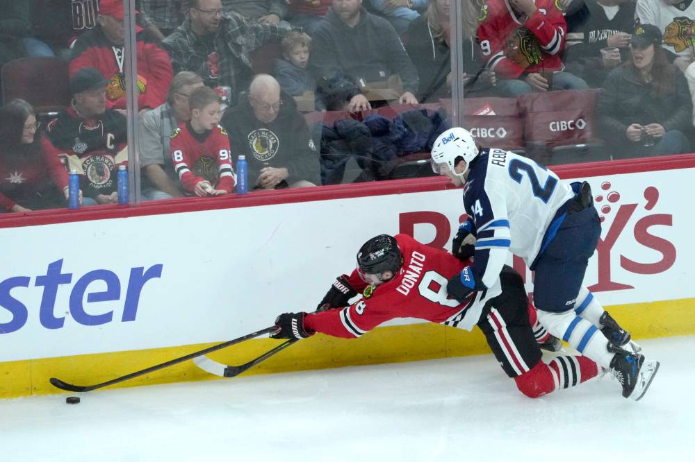CHARLES REX ARBOGAST / THE ASSOCIATED PRESS
Winnipeg Jets’ Haydn Fleury (24) checks Chicago Blackhawks’ Ryan Donato to the ice during the second period of an NHL game Saturday, Dec. 7, 2024, in Chicago.