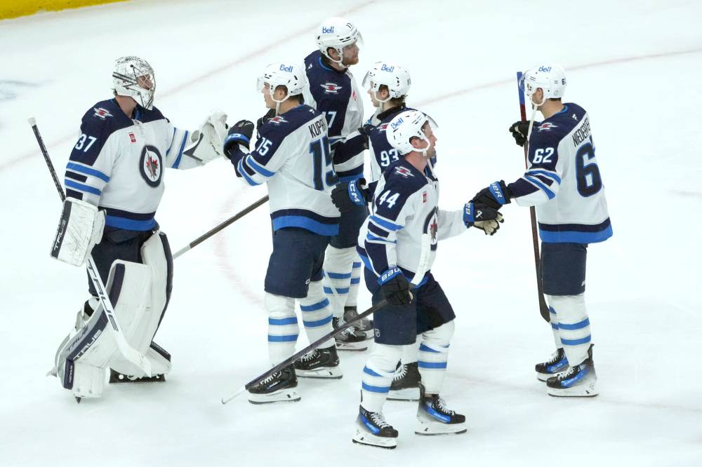 CHARLES REX ARBOGAST / THE ASSOCIATED PRESS
Winnipeg Jets goaltender Connor Hellebuyck (37) celebrate with teammates the team’s 4-2 win over the Chicago Blackhawks in an NHL game Saturday, Dec. 7, 2024, in Chicago.