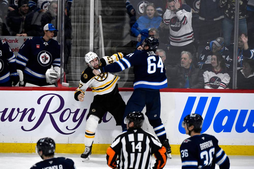 Fred Greenslade / THE CANADIAN PRESS
Jets D-man Logan Stanley (right) exchanges blows with Boston’s Mark Kastelic Tuesday night.