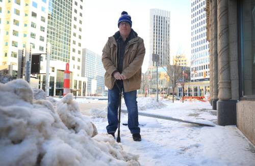RUTH BONNEVILLE / FREE PRESS Local - snow clearing Photo of David Kron, executive director, Cerebral Palsy Association of Manitoba outside near the office building he works in. David Kron has serious concerns that folks could be stuck in their homes is the city moves to a higher accumulation to clear residential streets. He uses a cane and manual wheelchair to get around. Dec 12th, 2024