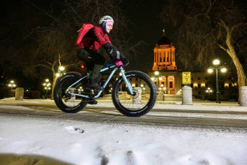 MIKE SUDOMA / FREE PRESS
                                Winnipeg Symphony Orchestra double bassist Daniel Perry cycles eastbound on Assiniboine Avenue past the Manitoba Legislative Building on his way to the Centennial Concert Hall for a performance.