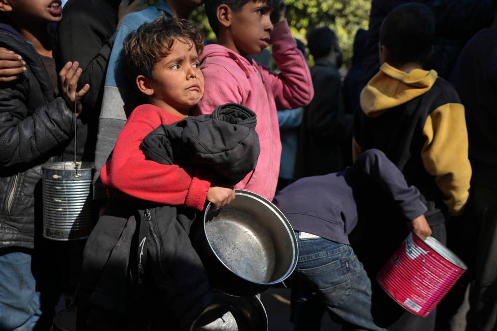 Abdel Kareem Hana / The Associated Press files
Palestinian children queue for food in Deir al-Balah, Gaza Strip on Dec. 13.