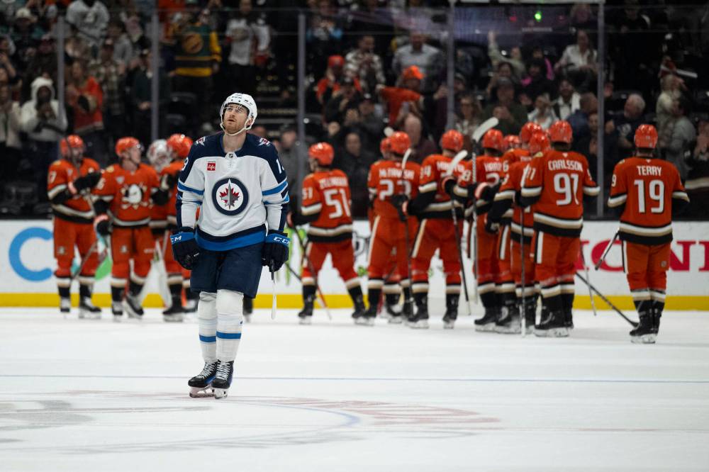 Kyusung Gong / The Associated Press
Jets forward Gabriel Vilardi leaves the ice Wednesday while the Ducks celebrate their come-from-behind victory in Anaheim.