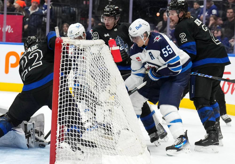 NATHAN DENETTE / THE CANADIAN PRESS
Jets centre Mark Scheifele digs out the puck to score his second goal of the game from behind the net Monday against the Toronto Maple Leafs.