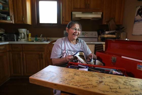 Cheryl Pelletier sits at her kitchen table in 2017 with a board signed by Jimmy Carter and the crew working on her house. (Ruth Bonneville / Free Press files)