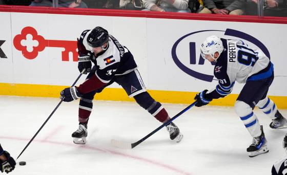 Colorado Avalanche centre Casey Mittelstadt, left, collects the puck as Winnipeg Jets centre Cole Perfetti defends during their Dec. 31 game. (David Zalubowski/ The Associated Press files)