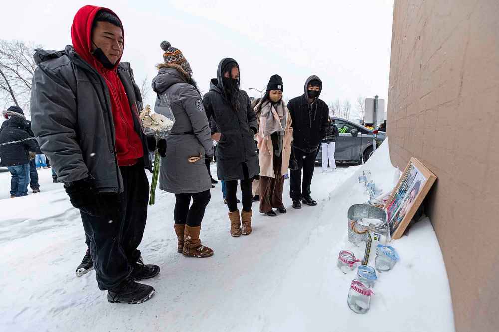 In February 2022, people place candles and flowers near the pickup window where John Lloyd Barrion worked. Barrion was killed while working at the beer vendor attached to the Travelodge on Notre Dame Avenue. (Daniel Crump / Free Press files)