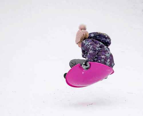 BROOK JONES/FREE PRESS
Josphine PIche, 9, who lives in St. Vital, goes airborn on a plastic saucer as she hits a bump while sliding down the stream bank at Omand's Creek on Christmas Day in Winnipeg, Man., Wednesday, Dec. 25, 2024.