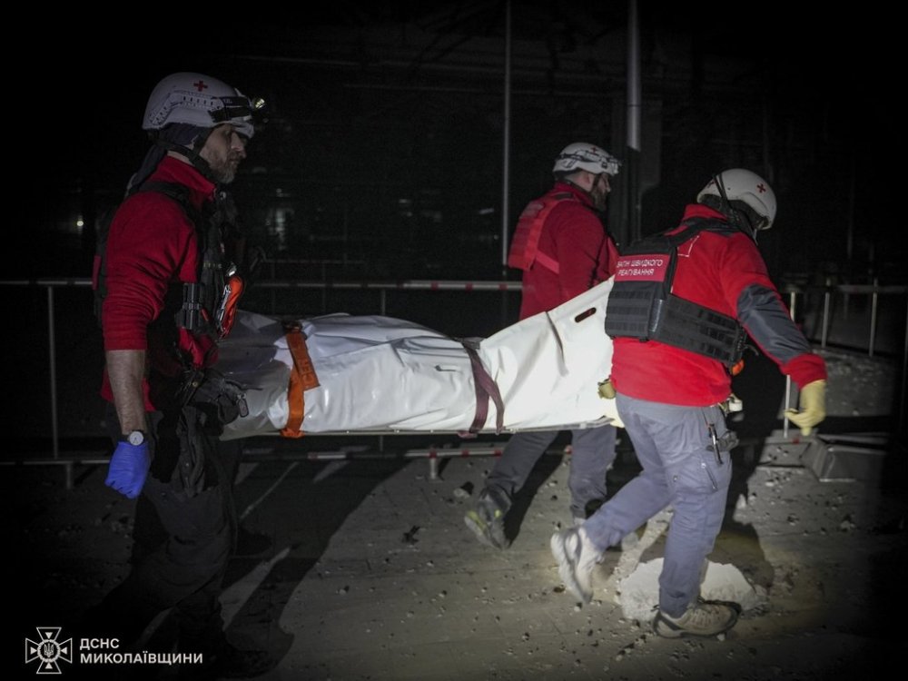 In this photo provided by the Ukrainian Emergency Service, rescuers carry the body of a civilian who was killed when a Russian drone hit a city food factory in Mykolaiv, Ukraine, Wednesday, Jan. 29, 2025. (Ukrainian Emergency Service via AP)
