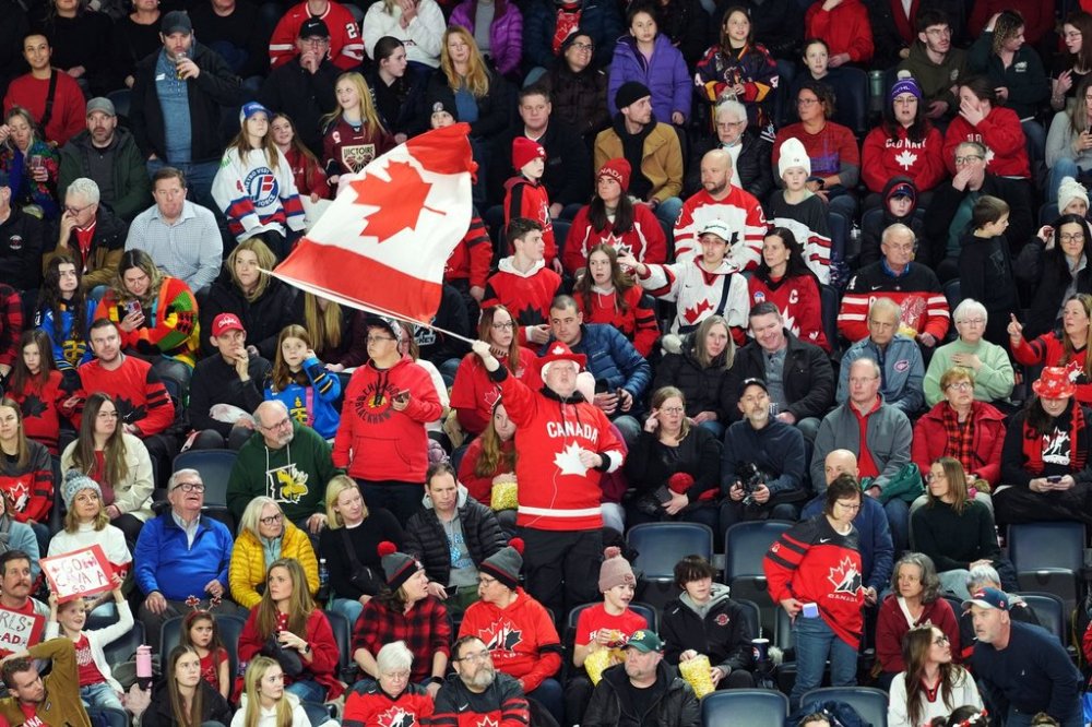 A Team Canada supporter waves a flag during Rivalry Series hockey action against Team USA in Halifax on Thursday, Feb. 6, 2025. THE CANADIAN PRESS/Darren Calabrese