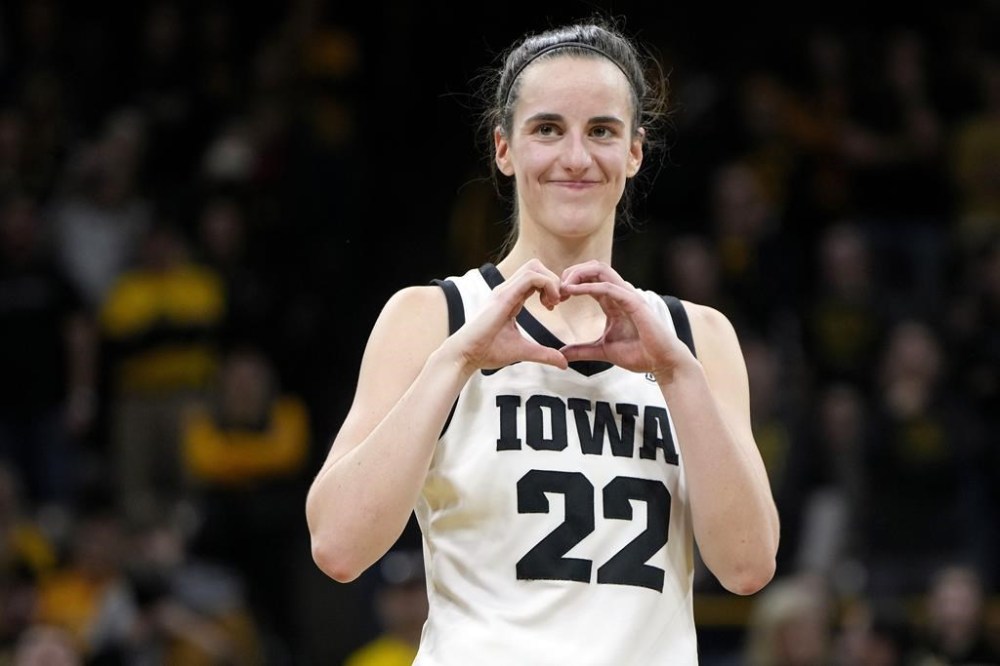 FILE - Iowa guard Caitlin Clark makes a heart gesture after the team's NCAA college basketball game against Michigan, Thursday, Feb. 15, 2024, in Iowa City, Iowa. Clark broke the NCAA women's career scoring record. (AP Photo/Matthew Putney, File)