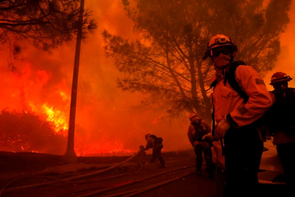 Firefighters battle the advancing Palisades Fire in the Pacific Palisades neighborhood of Los Angeles, Tuesday, Jan. 7, 2025. (AP Photo/Etienne Laurent)
