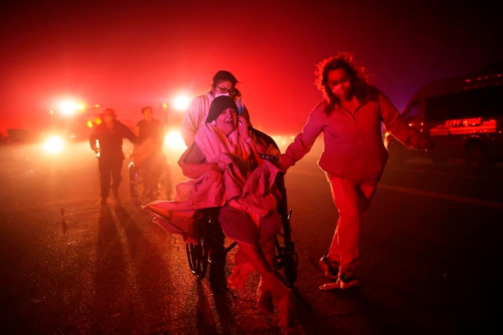 Residents of a senior center are evacuated as the Eaton Fire approaches Tuesday, Jan. 7, 2025 in Altadena, Calif. (AP Photo/Ethan Swope)