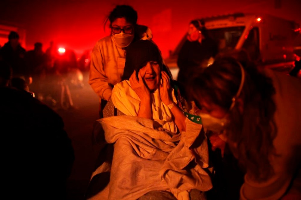 A resident of a senior center is evacuated as the Eaton Fire approaches Tuesday, Jan. 7, 2025 in Altadena, Calif. (AP Photo/Ethan Swope)