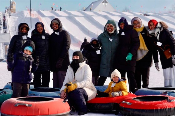 Nasrieen Habib, centre right with green coat, and some of the members of the outdoors group she founded for Muslim women at a snow tubing hill at Elm Creek Park Reserve in Maple Grove, Minn. (Mark Vancleave / The Associated Press)
