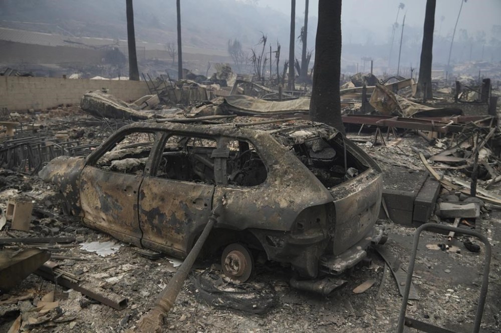The Palisades Fire ravages a neighborhood amid high winds in the Pacific Palisades neighborhood of Los Angeles, Wednesday, Jan. 8, 2025. (AP Photo/Damian Dovarganes)