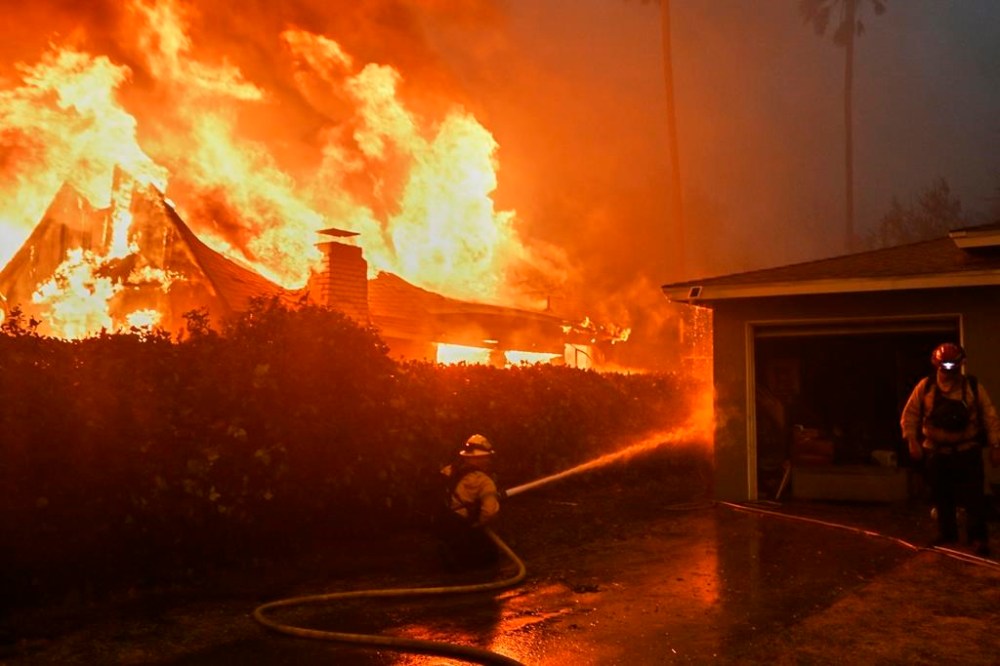 Fire crews battle the Eaton Fire next to a fully engulfed residence, Wednesday, Jan. 8, 2025 in Altadena, Calif. (AP Photo/Nic Coury)