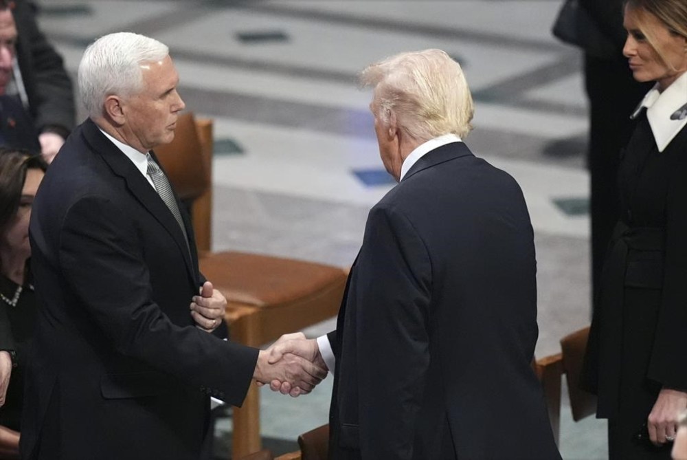 President-elect Donald Trump shakes hands with former Vice President Mike Pence as Melania Trump watches before the state funeral for former President Jimmy Carter at Washington National Cathedral in Washington, Thursday, Jan. 9, 2025. (AP Photo/Jacquelyn Martin)